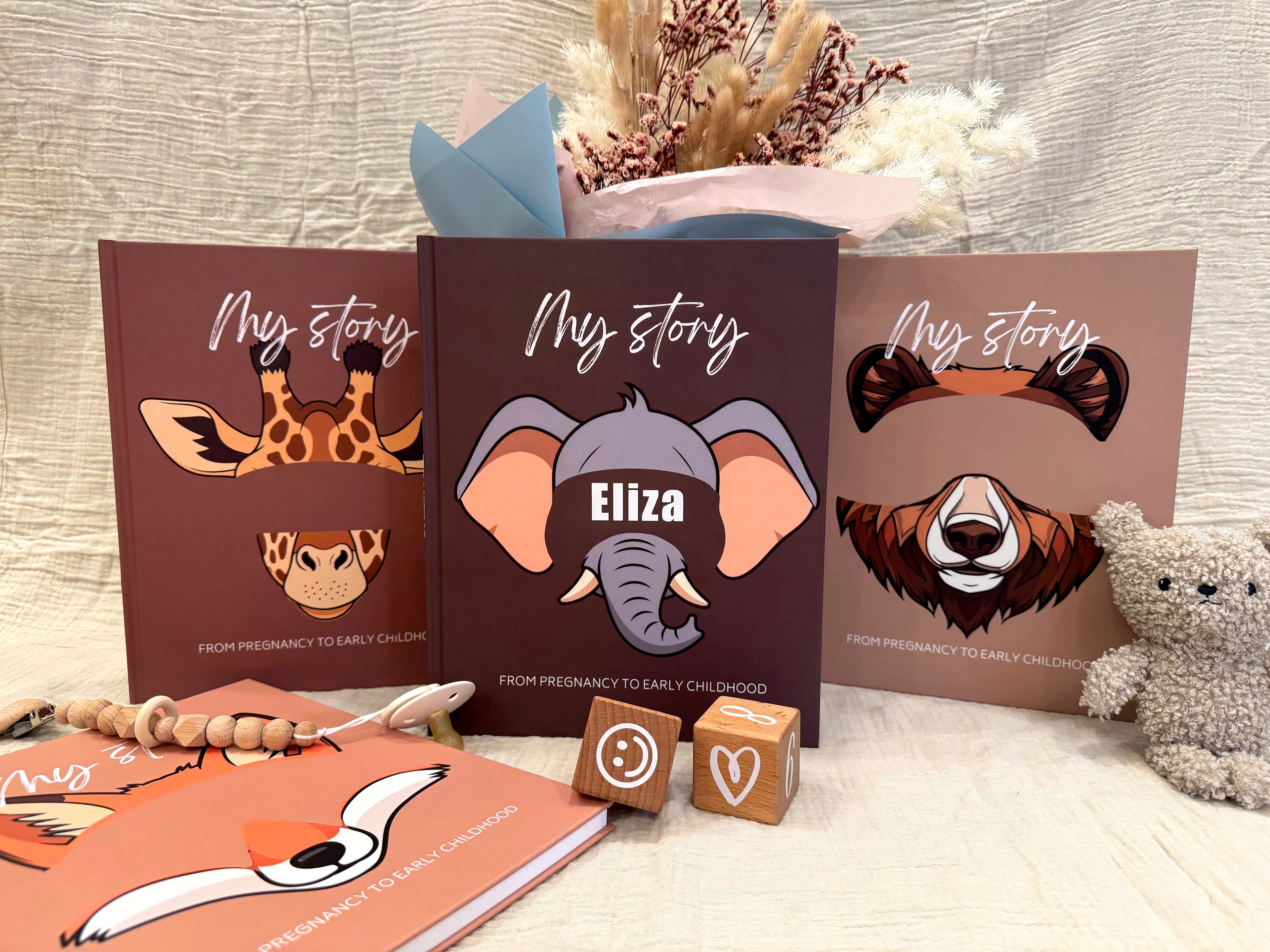 Personalized baby keepsake book sets with animal illustrations, including a giraffe, elephant, and bear.